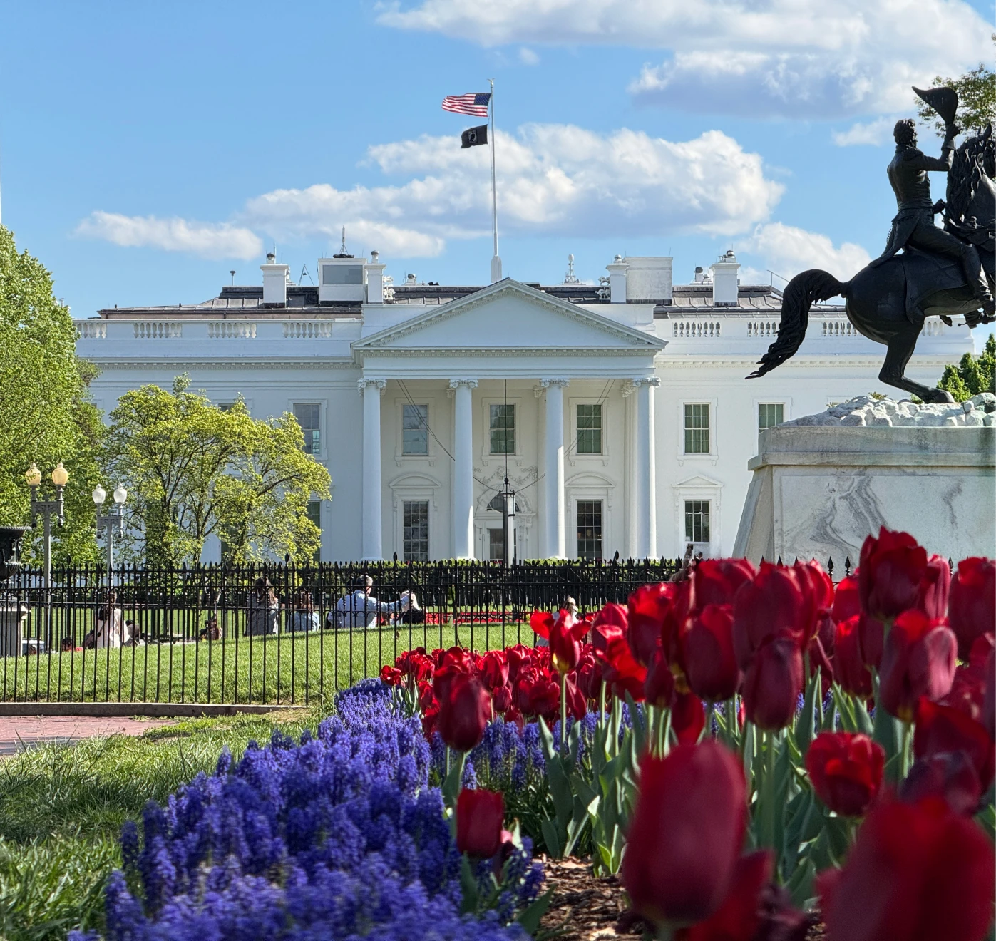 White House with vibrant flowers and statue.