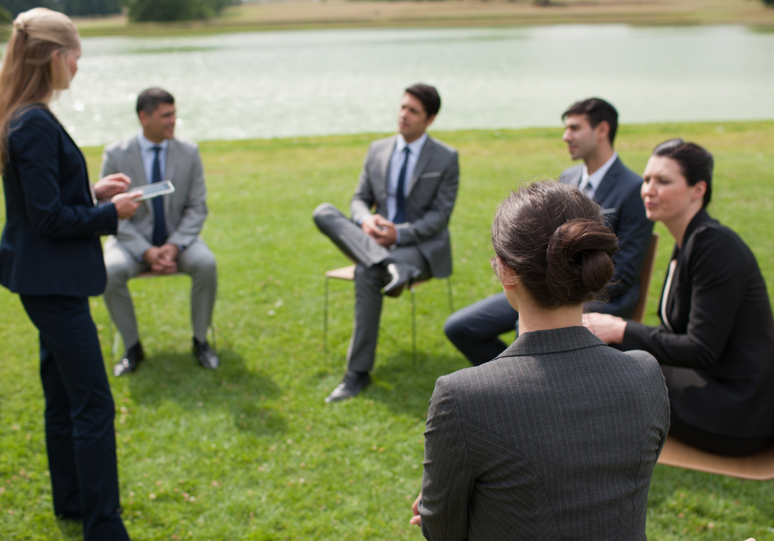 Outdoor business meeting by a lake.